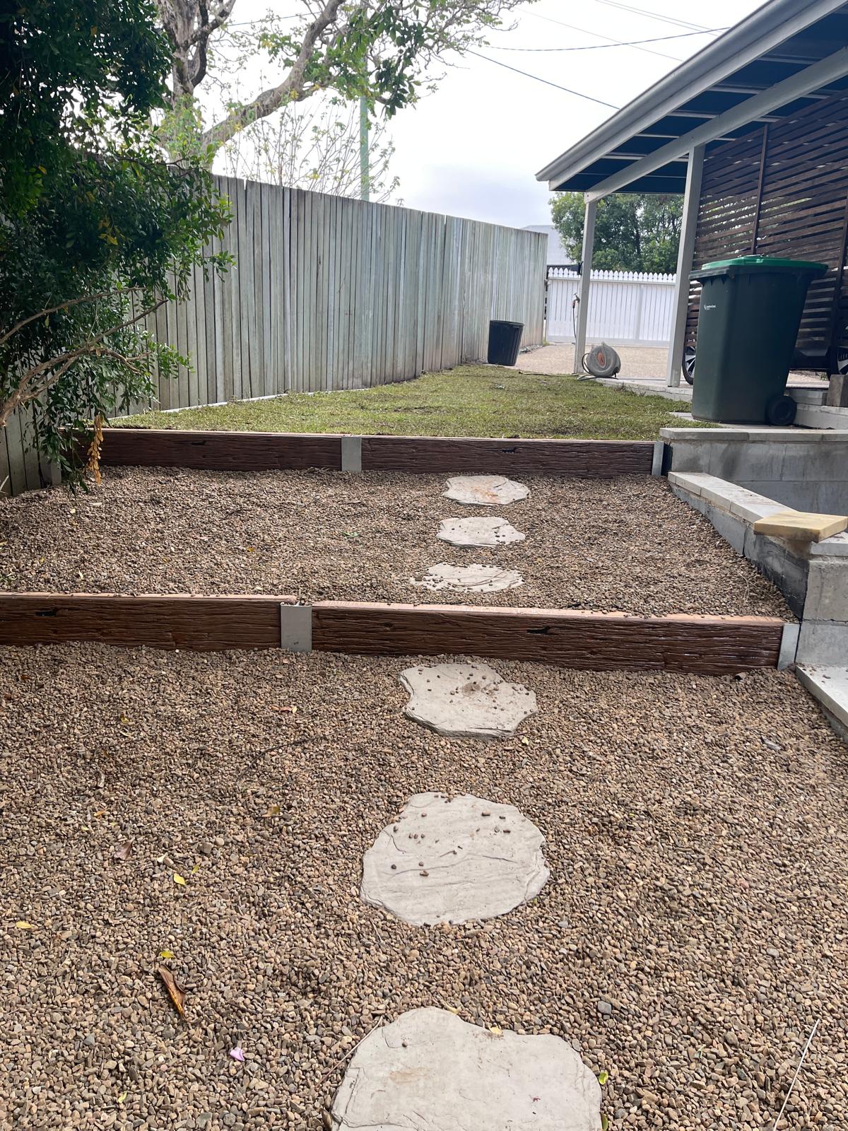 Finished gravel yard with concrete steppers and sleeper retaining by Scapem8