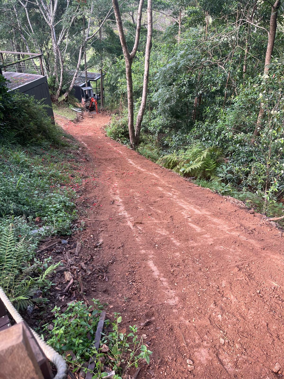Steep red dirt access track prepared for earthworks in the Noosa Hinterland